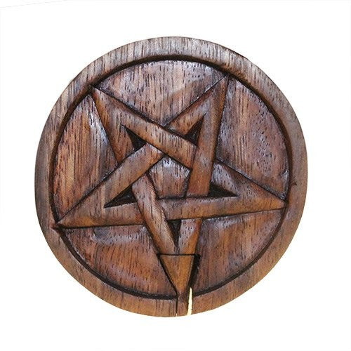 Wooden plaque with a carved pentagram, featuring interlocking star and circular designs. The surface has a smooth, polished finish, set against a plain white background.