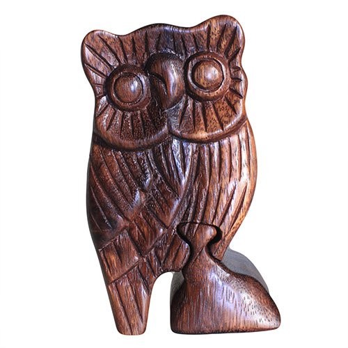A wooden owl figurine stands upright, showcasing detailed carving with textured feathers and large circular eyes, set against a plain white background.