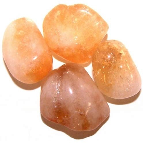 Four tumbled stones sit grouped closely together, displaying hues of orange, yellow, and brown against a plain white background.