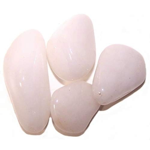 Four tumbled rose quartz stones are grouped closely together on a white surface.