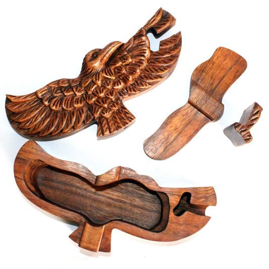 Wooden carved eagle puzzle box with separate, intricately designed pieces, including wings and head, on a white background. The box's interior is hollow for storage.