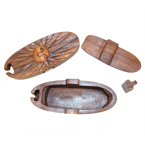 Three intricately carved wooden objects, including a lidded box and two decorative pieces with sun-like patterns, are arranged on a white surface. The box has an open compartment.