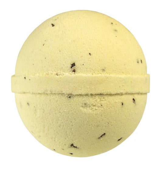 A round, pale yellow bath bomb with small dark speckles is centered against a plain white background, displaying its compact, textured surface.
