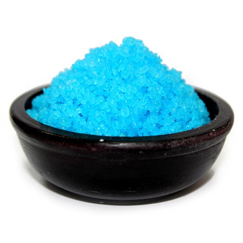 Bright blue granules rest in a dark bowl.