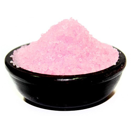 Pink granular material rests in a dark bowl.
