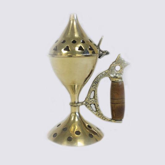 A brass incense burner with a conical lid featuring circular and triangular cutouts, stands on a flared base. The ornate handle has a wooden grip, set against a plain background.