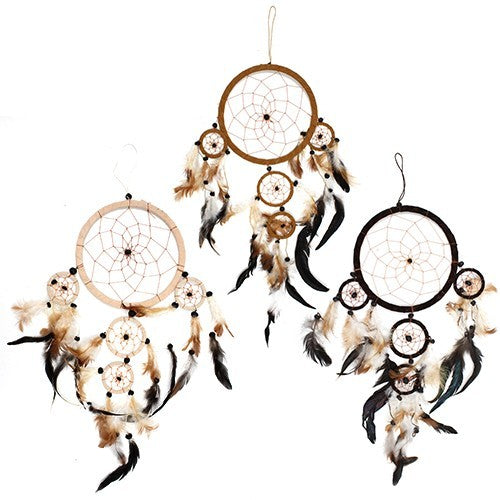 Three dreamcatchers hang, adorned with feathers. Circular woven frames with smaller circles and beads are suspended. The dreamcatchers feature various color schemes, including brown, beige, and black.