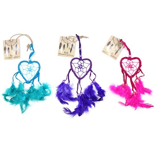 Three heart-shaped dream catchers hang, each adorned with feathers and beads in teal, purple, and pink. Bali Dream Catchers.