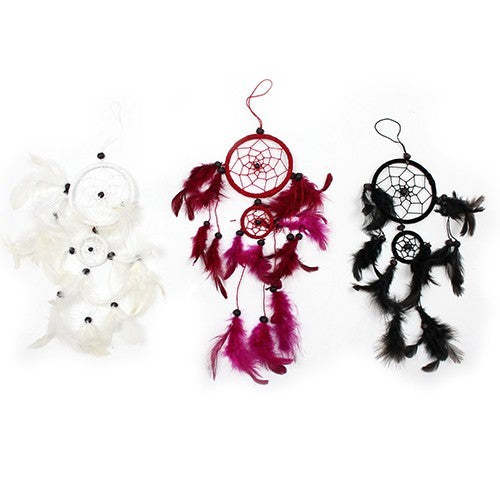 Three dreamcatchers hang, adorned with feathers. One features white feathers, one burgundy, and one black. Each is composed of multiple rings and beads.