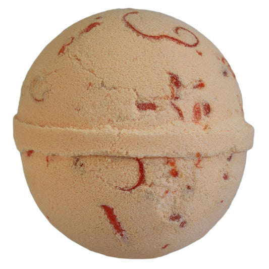 A textured, beige bath bomb with red swirls and specks, sits against a plain white background, highlighting its spherical shape and intricate detailing.