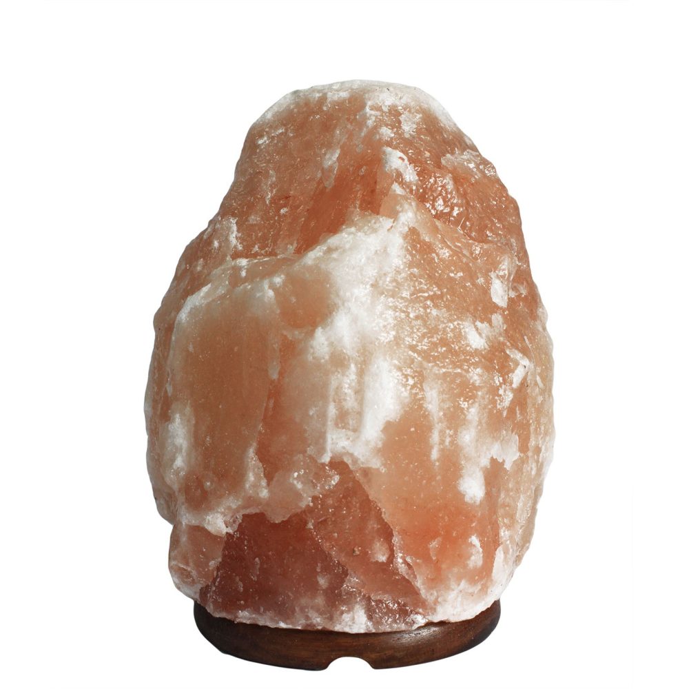 A large, rough pink salt lamp rests on a small wooden base. It is situated against a plain white background.