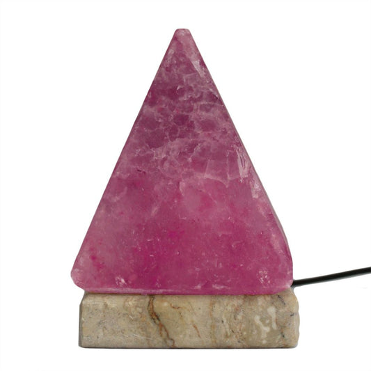 A pink, triangular crystal lamp sits on a marble base, plugged in with a visible black cord, against a plain white background.