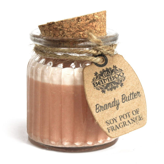 Small ribbed glass jar holding a pink soy candle, corked and tied with twine while a kraft tag hangs against a white background Text on tag: BAMBOO Brandy Butter SOY POT OF FRAGRANCES