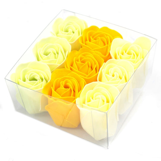 Nine foam roses arranged in three rows sit inside a clear plastic box against a white background, their yellow and pale cream petals tightly coiled.