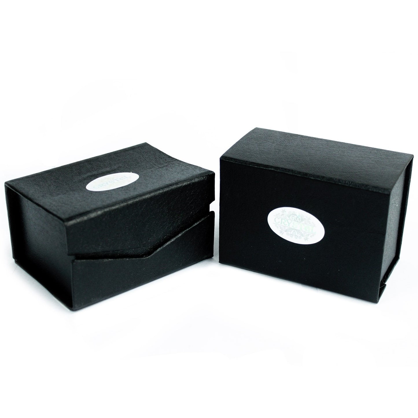 Two black rectangular boxes sit on a white surface; one is partially open. Both have a white oval sticker labeled "CRYSTAL" with decorative elements.