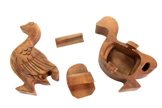 Wooden duck-shaped puzzle box disassembled into four parts; two halves with carved details, a removable bottom cover, and a small locking piece. Set on a plain white background.