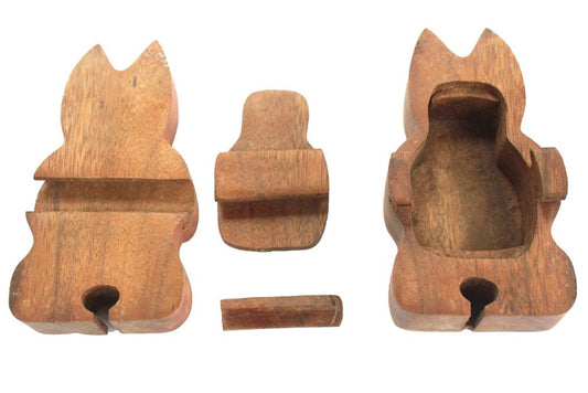 A wooden puzzle box is disassembled, showing three components: a cat-shaped outer shell, a lid, and a small locking piece. The context is a plain white background.