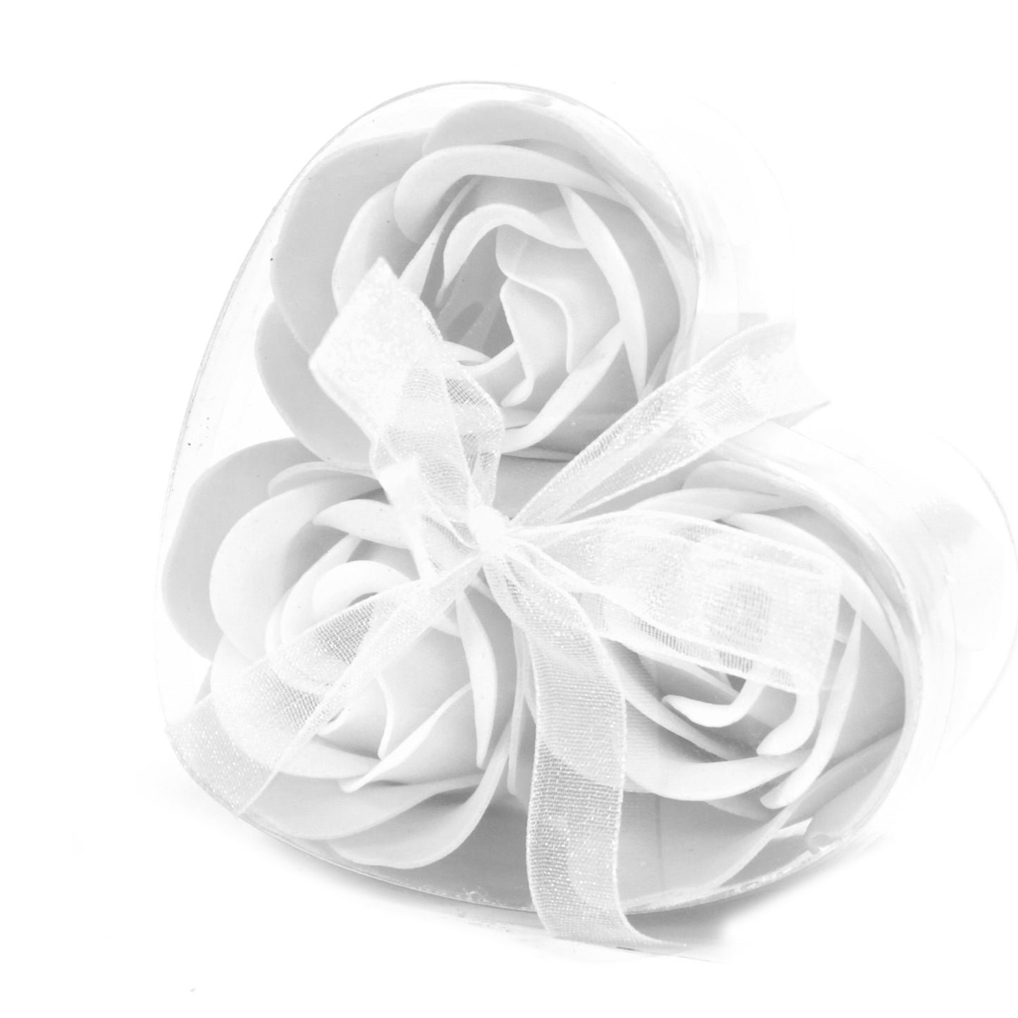 Soap flowers rest in a clear, heart-shaped container tied with a sheer, white ribbon, set against a stark white background.