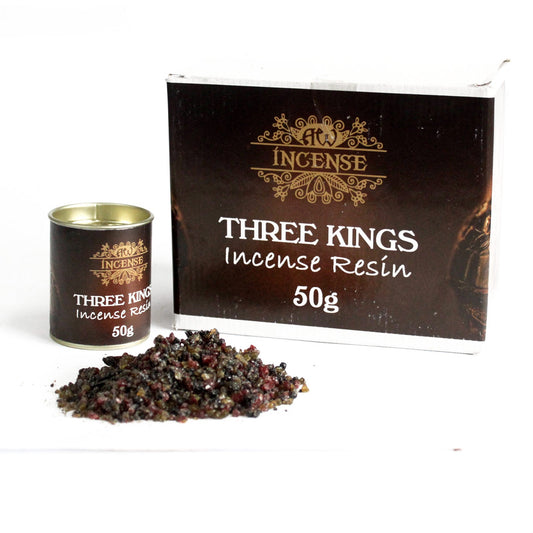 A small tin and a box labeled "THREE KINGS Incense Resin 50g" sit beside a pile of dark, granular incense resin on a white surface.