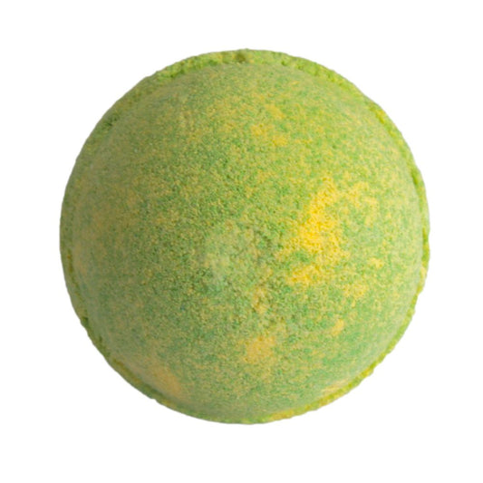 A round, green and yellow-speckled bath bomb rests against a plain white background, conveying a vibrant and slightly textured appearance.