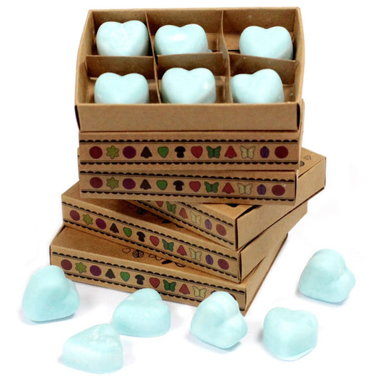 Heart-shaped wax melts are arranged in a stack of boxes, decorated with small icons, on a white surface.