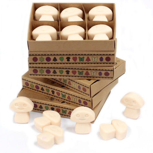 Mushroom-shaped wax melts are arranged in cardboard boxes, stacked on a white surface. The boxes are decorated with a repeating pattern of woodland icons.