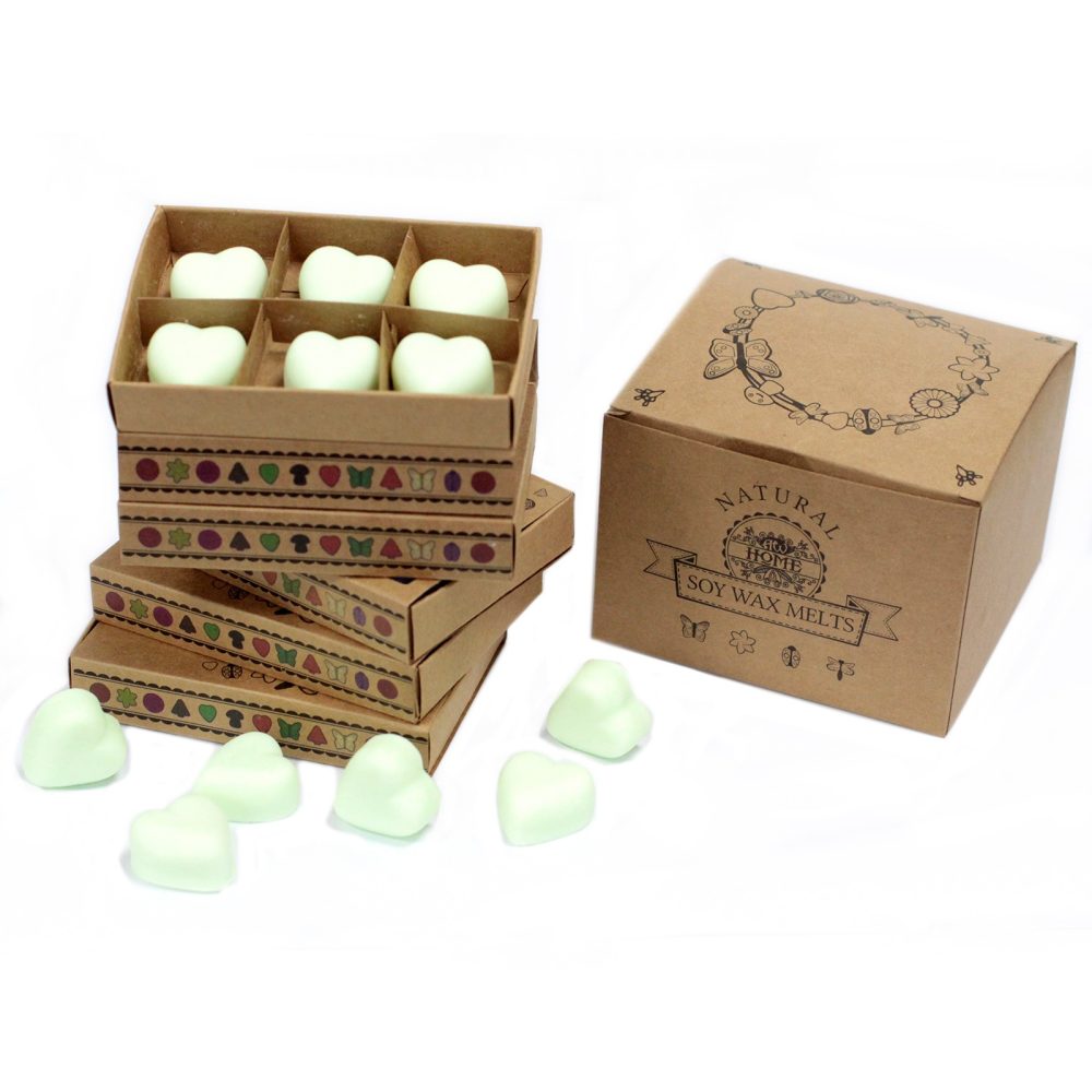 Heart-shaped soy wax melts are packaged in stacked cardboard boxes with decorative patterns.  A larger box is also present, labeled "NATURAL SOY WAX MELTS".
