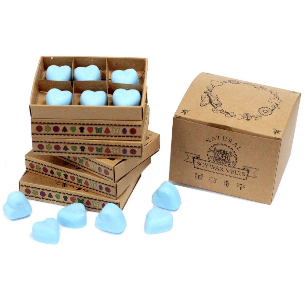 Light blue, heart-shaped soy wax melts are arranged in a stack of small, decorated boxes.  A larger box is also present, labeled "NATURAL SOY WAX MELTS".