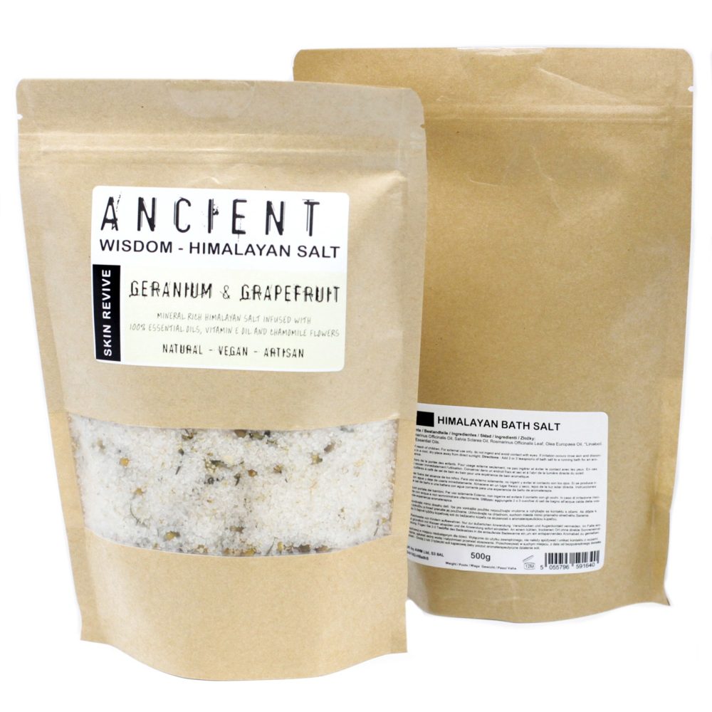 Two brown paper pouches stand, one filled with "ANCIENT WISDOM - HIMALAYAN SALT GERANIUM & GRAPEFRUIT," showing salt crystals through a clear section. The second, reading "HIMALAYAN BATH SALT," is plain.