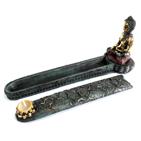 Buddha figurine sits serenely on an intricately carved incense holder. Adjacent, an embossed piece features floral patterns and holds a small candle. The design is detailed and ornamental.