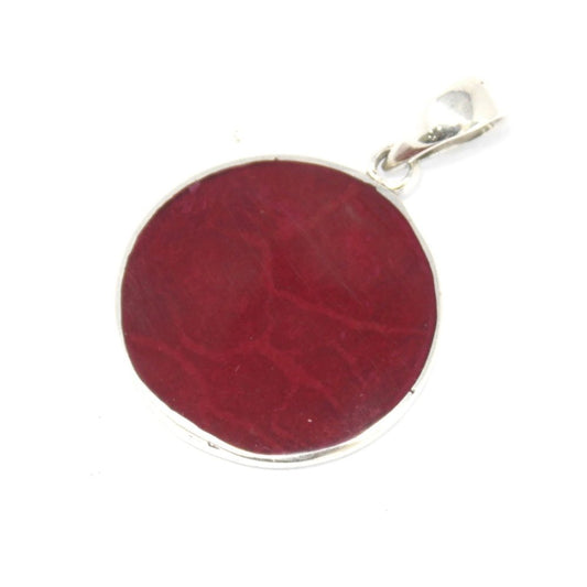 A circular, blood-red gemstone pendant with swirling patterns sits against a stark white background. It's rimmed with silver and has a silver loop at the top for attachment.
