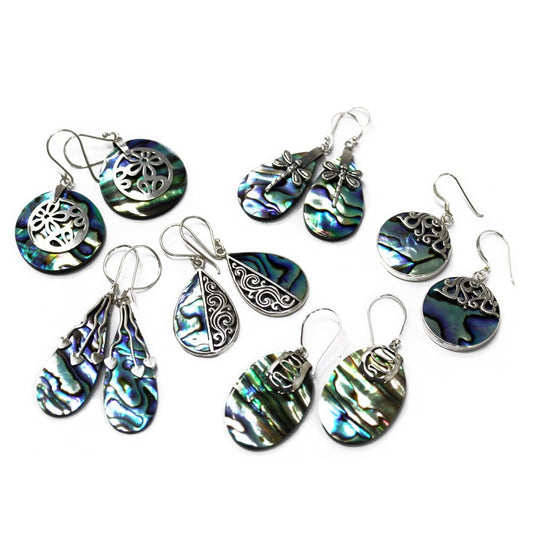 Several pairs of earrings display their iridescent blue-green abalone shell details, accented with silver, against a stark white backdrop.
