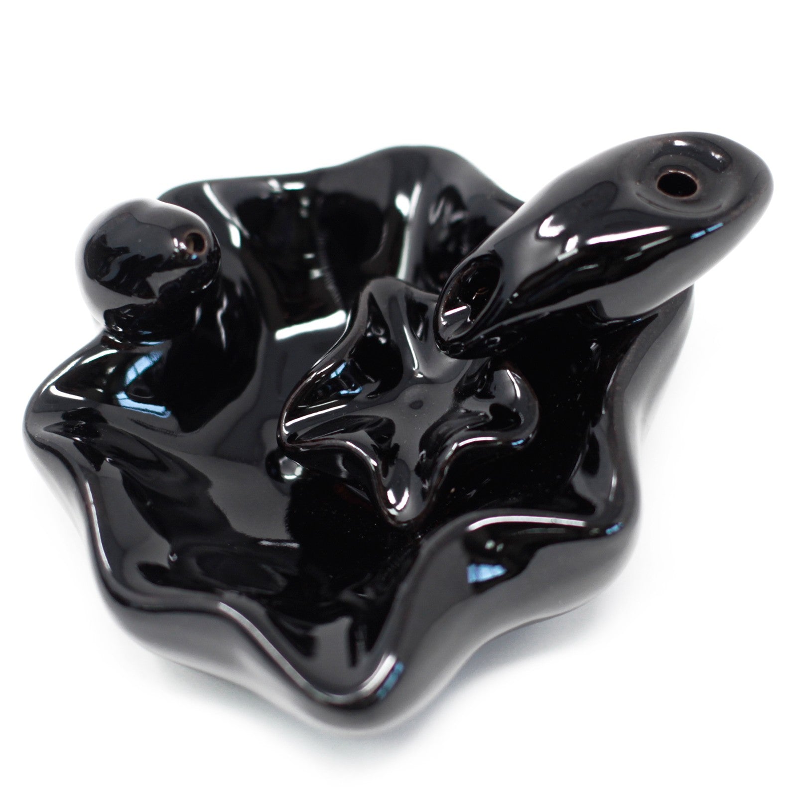 Sleek black ceramic incense holder with fluid lines, features a round ball and a flat star shape, set against a plain background.