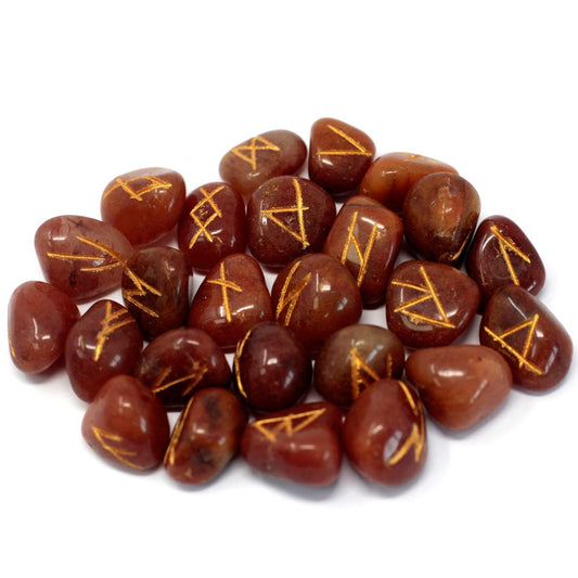 Polished, dark red stones display gold-colored, angular symbols on their surfaces, scattered across a white background.