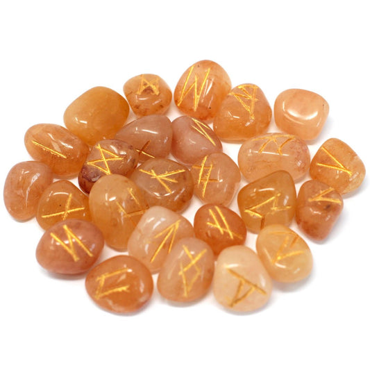 Orange-toned, smooth stones, etched with golden rune-like symbols, scatter on a plain white background.