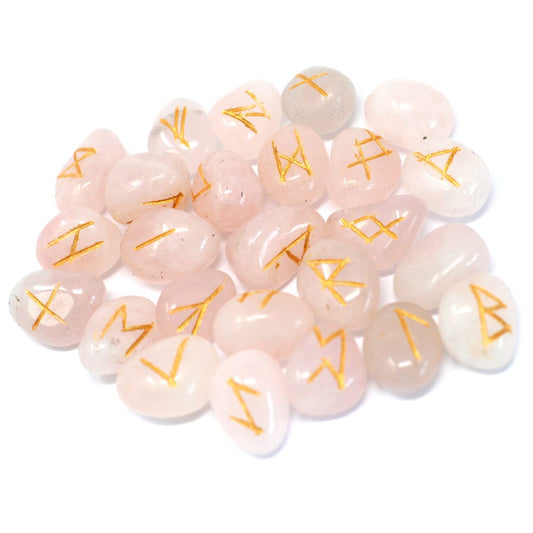 Rose quartz stones sit scattered across a white surface, each inscribed with a golden rune.