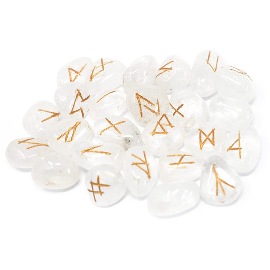 Quartz stones lay piled on a white surface, each piece etched with golden-brown rune symbols.