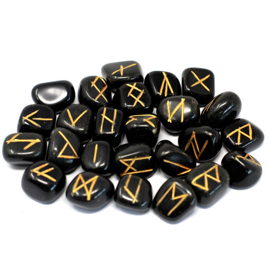 Black, polished stones with carved golden symbols are scattered randomly on a bright white background.