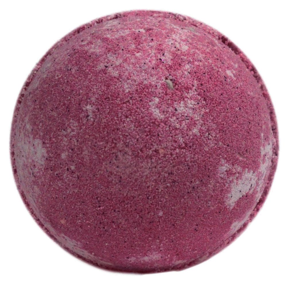 A spherical, pink bath bomb sits stationary, with a slightly textured surface. Its mottled white accents suggest mixing or variation in composition, against a plain backdrop.