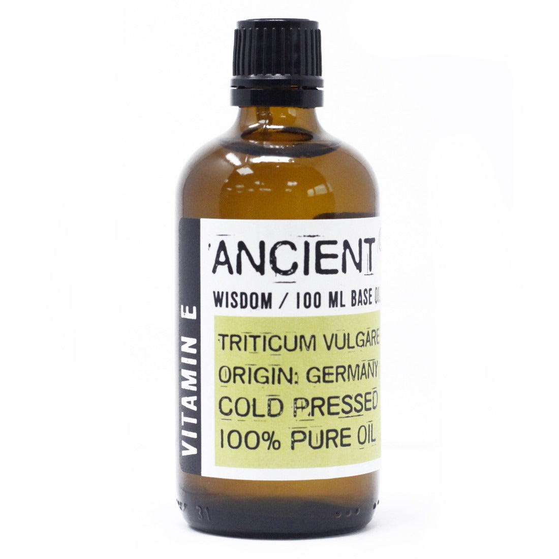 An amber bottle of "ANCIENT WISDOM / 100 ML BASE O" oil sits on a white surface. The label includes "VITAMIN E," "TRITICUM VULGARE," "ORIGIN: GERMANY," "COLD PRESSED," and "100% PURE OIL."
