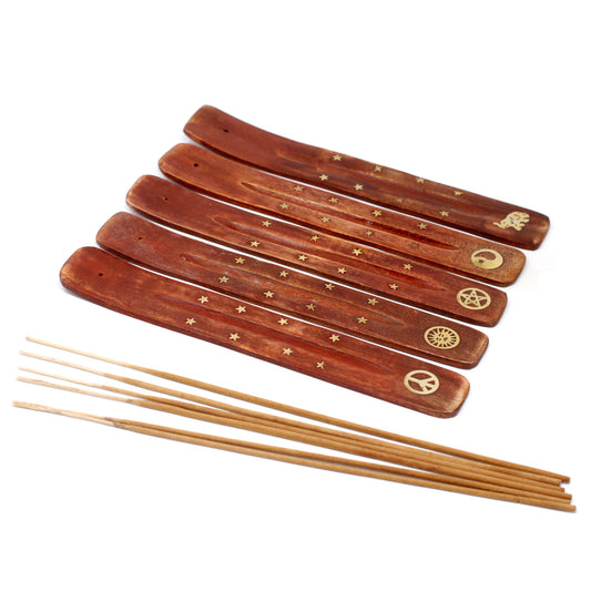 Wooden incense holders with engraved symbols and star patterns are arranged in a row. A group of incense sticks rests beside them, set against a white background.