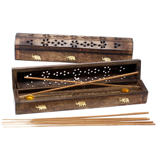 Wooden incense box with floral and elephant carvings. Opened, displaying incense sticks inside with two sticks placed diagonally. Several sticks rest outside on a white background.