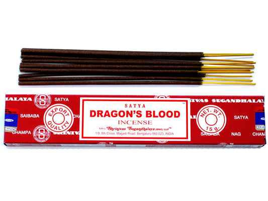 Incense sticks are resting on a red box labeled "SATYA DRAGON'S BLOOD INCENSE." The box features text: "Export Quality, Net Wt. 15g, Shrinivas Sugandhalaya, Bengaluru, India."