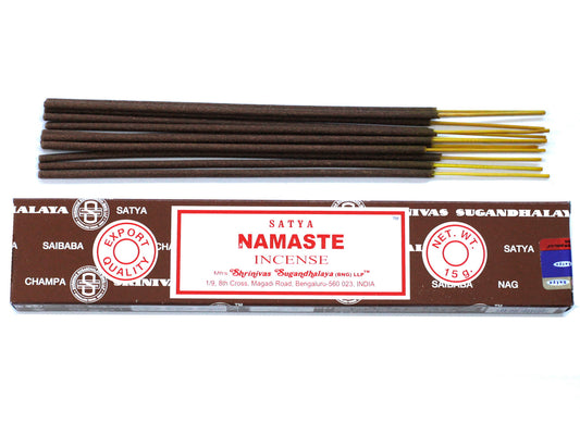 Incense sticks with brown and yellow ends lay above their packaging. The brown box reads: "SATYA NAMASTE INCENSE" by Shrinivas Sugandhalaya, Bengaluru, India, net weight 15g, EXPORT QUALITY.