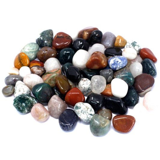 Polished stones, ranging from white to red to green, pile together in a heap on a white surface.