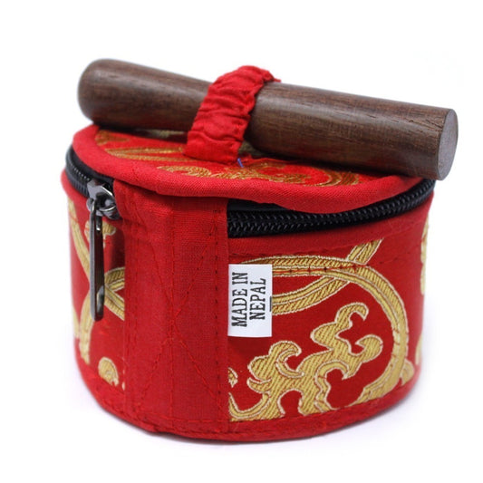 A red and gold embroidered case with a black zipper holds a wooden stick on top, labeled "MADE IN NEPAL." The case is ornate, resting on a plain background.