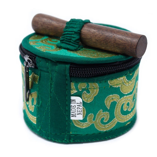 A cylindrical, green fabric case with golden patterns holds a wooden object on top. A zipper encloses it, and a tag reads "MADE IN NEPAL."