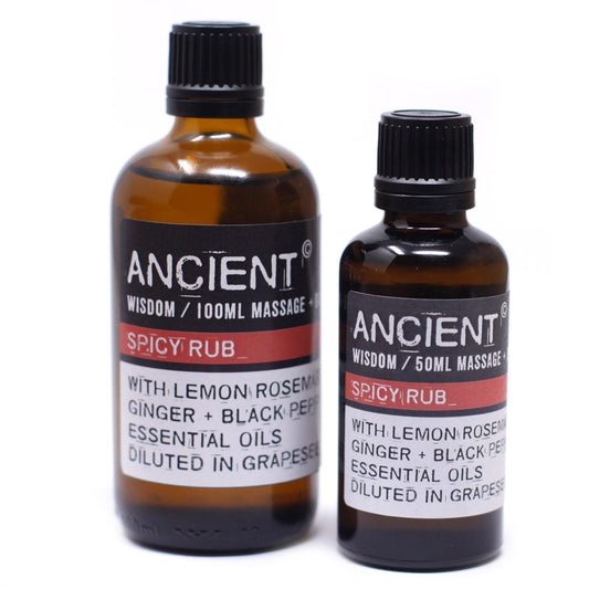 Two brown glass bottles stand on a white surface. The bottles are labeled “ANCIENT, WISDOM / 100ML MASSAGE + SPICY RUB + WITH LEMON ROSEMAR, GINGER + BLACK PEP, ESSENTIAL OILS, DILUTED IN GRAPESE” and “ANCIENT, WISDOM / 50ML MASSAGE + SPICY RUB + WITH LEMON ROSEMAR, GINGER + BLACK PER, ESSENTIAL OILS, DILUTED IN GRAPESE”.