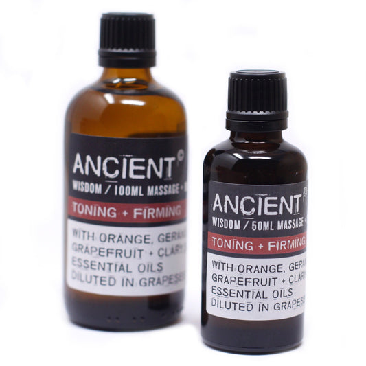 Two brown glass bottles stand on a white surface. Labels on the bottles read "ANCIENT WISDOM/100ML MASSAGE TONING + FIRMING WITH ORANGE, GERAR GRAPEFRUIT + CLARY ESSENTIAL OILS DILUTED IN GRAPES" and "ANCIENT WISDOM/50ML MASSAGE TONING + FIRMING WITH ORANGE, GERA GRAPEFRUIT + CLARY ESSENTIAL OILS DILUTED IN GRAPES".