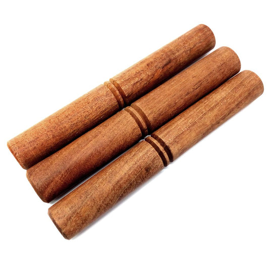 Three wooden claves rest parallel to each other, displaying a smooth surface and a warm brown tone, on a white background.